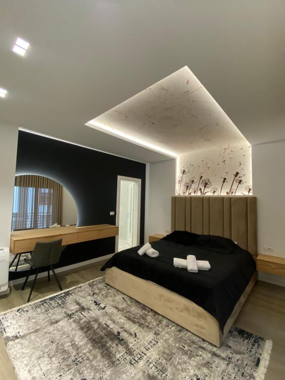 a bedroom with a large bed with two towels at Riar Apartaments in Korçë