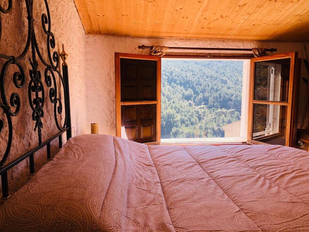 a bedroom with a bed and a large window at Vivienda turística LA CAPE in Segura de la Sierra