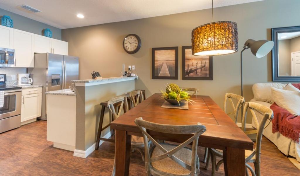 a kitchen and dining room with a wooden table and chairs at Townhome at West Lucaya Resort 3212 in Orlando