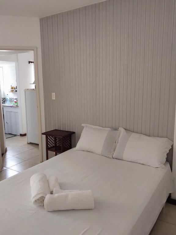 Un dormitorio con una cama blanca con toallas. en APARTAMENTO ITAIGARA, en Salvador