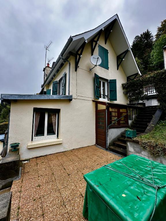 une maison avec une table verte devant elle dans l'établissement Maison Le Barbier 10pers Le Mont Dore, à Le Mont-Dore