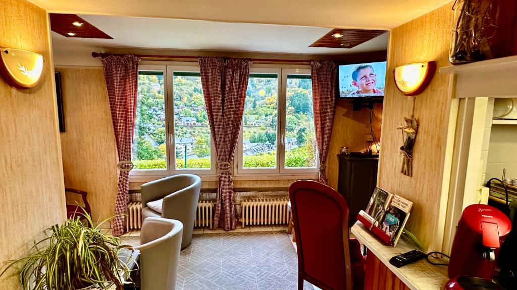 a living room with a window and a television at Maison Le Barbier 10pers Le Mont Dore in Le Mont-Dore