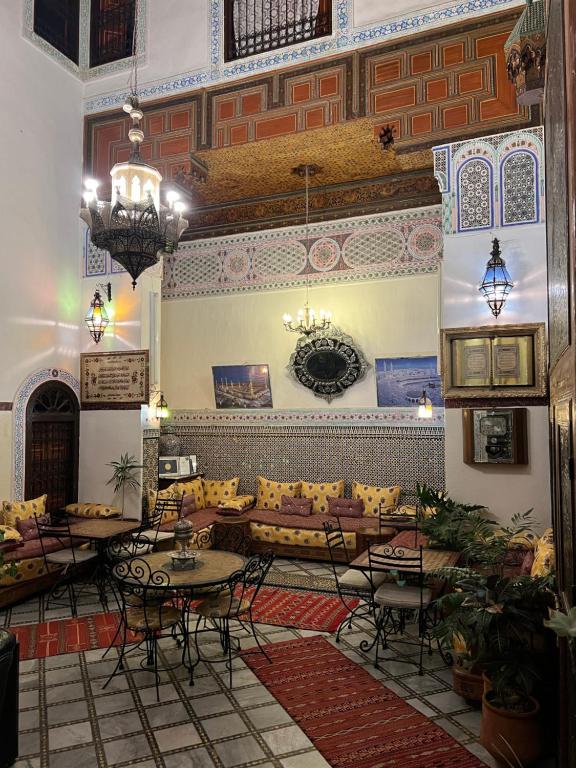sala de estar con sofá, mesas y sillas en Riad Meski, en Fez