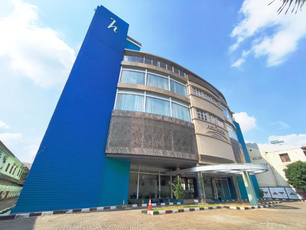 a large blue building with a blue wall at Horison TC UPI Serang in Banjar