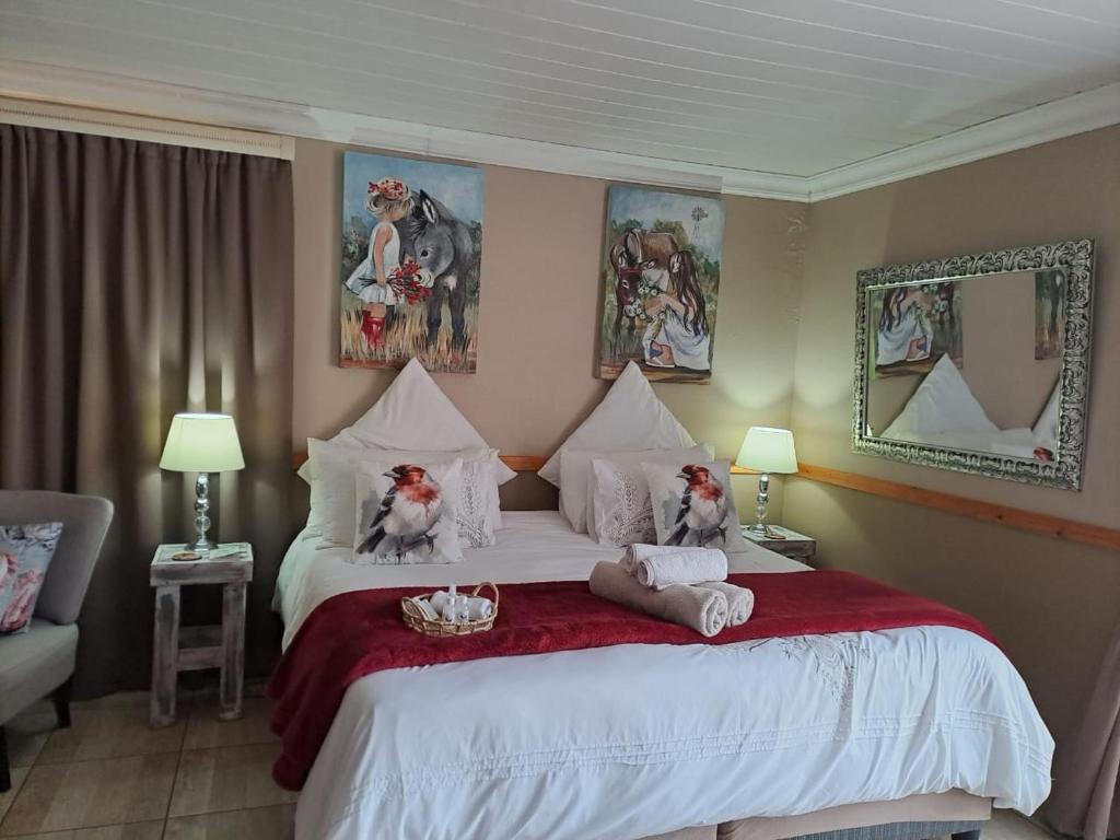 a bedroom with a large bed with two dogs on it at Rus en Rose Gastehuis in Bloemfontein