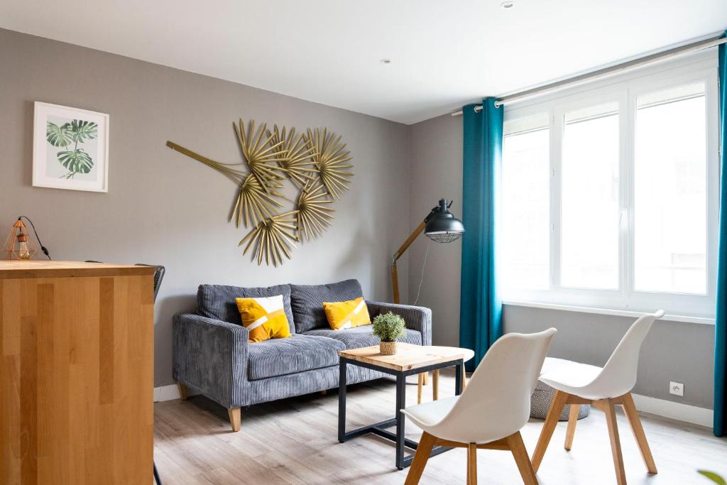 un salon avec un canapé, une table et des chaises dans l'établissement Charmant appartement 4 personnes en centre-ville, à Caen