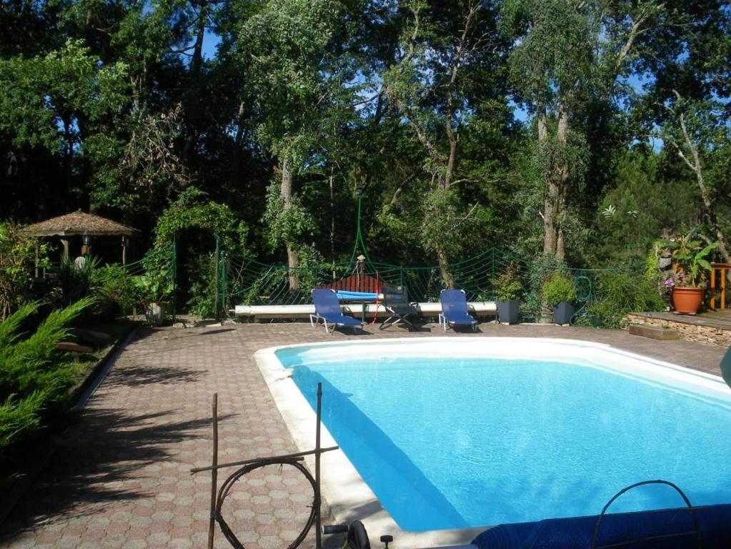 una piscina con 2 sillas y una mesa en Les sources, en Gourbera