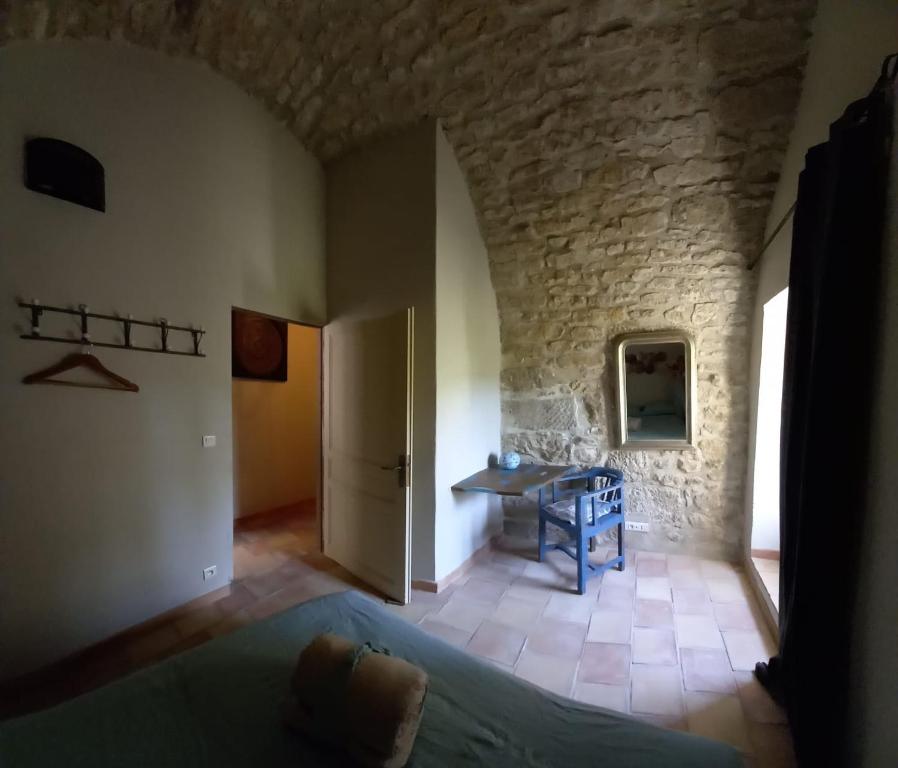 a bedroom with a bed and a stone wall at Charming Village Getaway in Bonnieux in Bonnieux