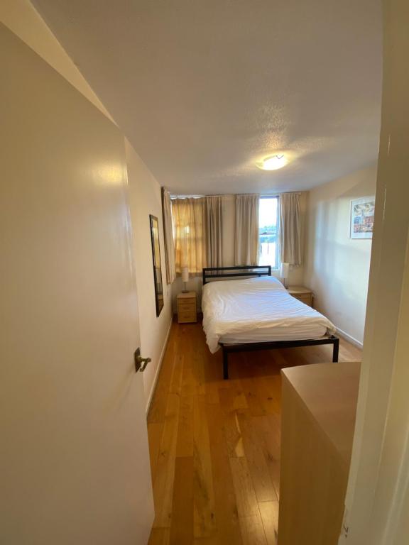 een kleine slaapkamer met een bed en een raam bij Confortable and central room in Londen