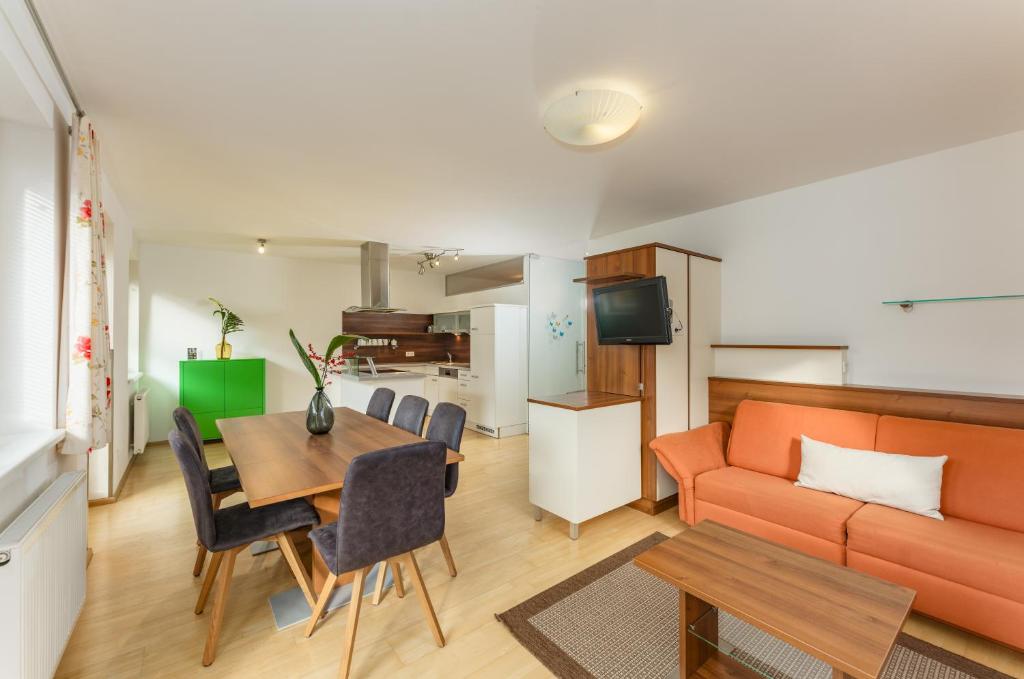 斯拉德明的住宿－Appartement Lilie by Schladming Appartements，客厅配有橙色沙发和桌子