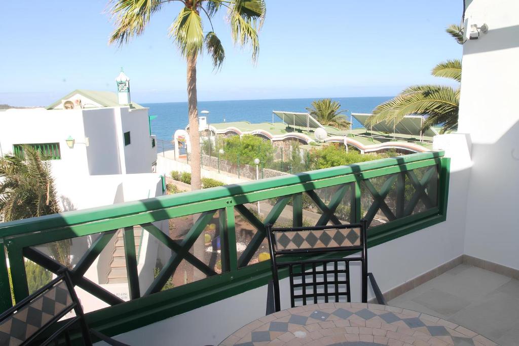balkon z krzesłem i widokiem na ocean w obiekcie Bonito apartamento cerca la playa w mieście San Bartolomé