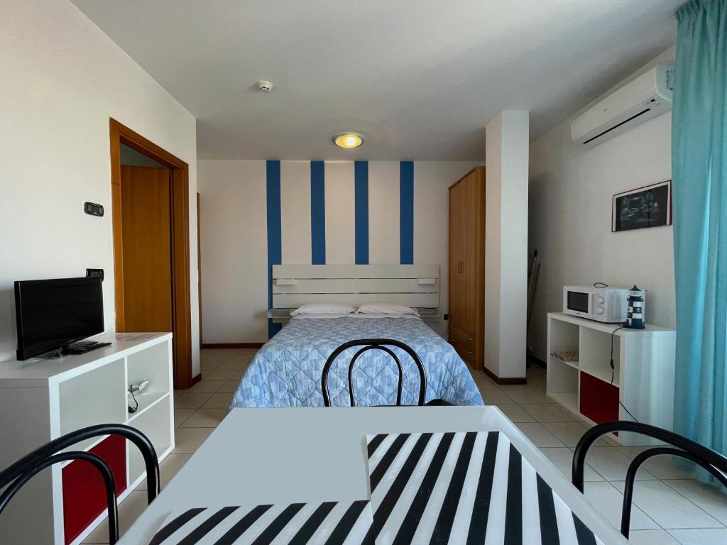 Residence Villa Azzurra في ريميني: غرفة نوم صغيرة بها سرير وتلفزيون