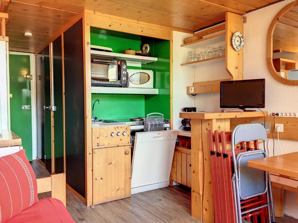 a small kitchen with green walls and a table in a caravan at Studio Les Arcs 1800, 2 pièces, 5 personnes - FR-1-346-426 in Arc 1800