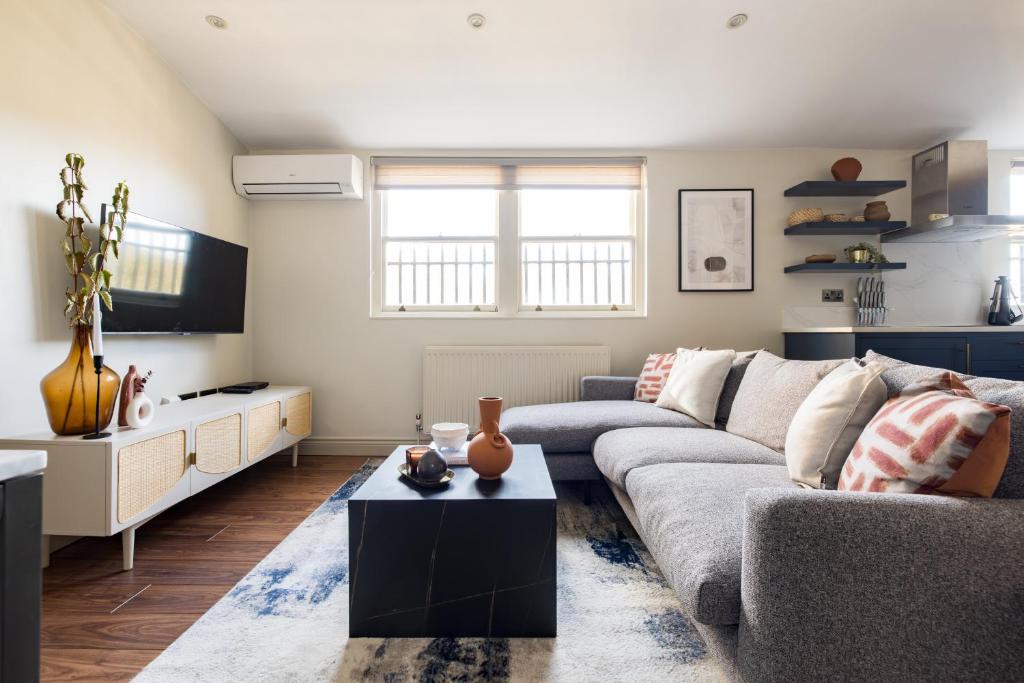 ein Wohnzimmer mit einem Sofa und einem Tisch in der Unterkunft The Marylebone Escape - Lovely 1BDR Flat in London