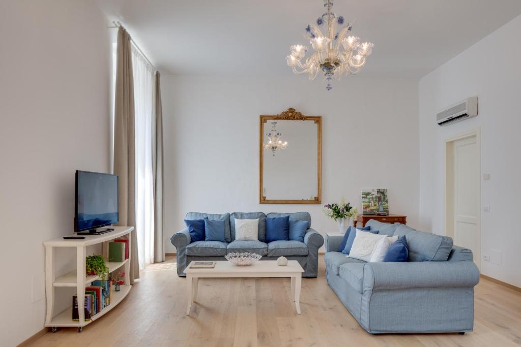 sala de estar con sofá azul y mesa en Rambaldi Apartments Casa nr 6 with shared Terrace, en Bardolino