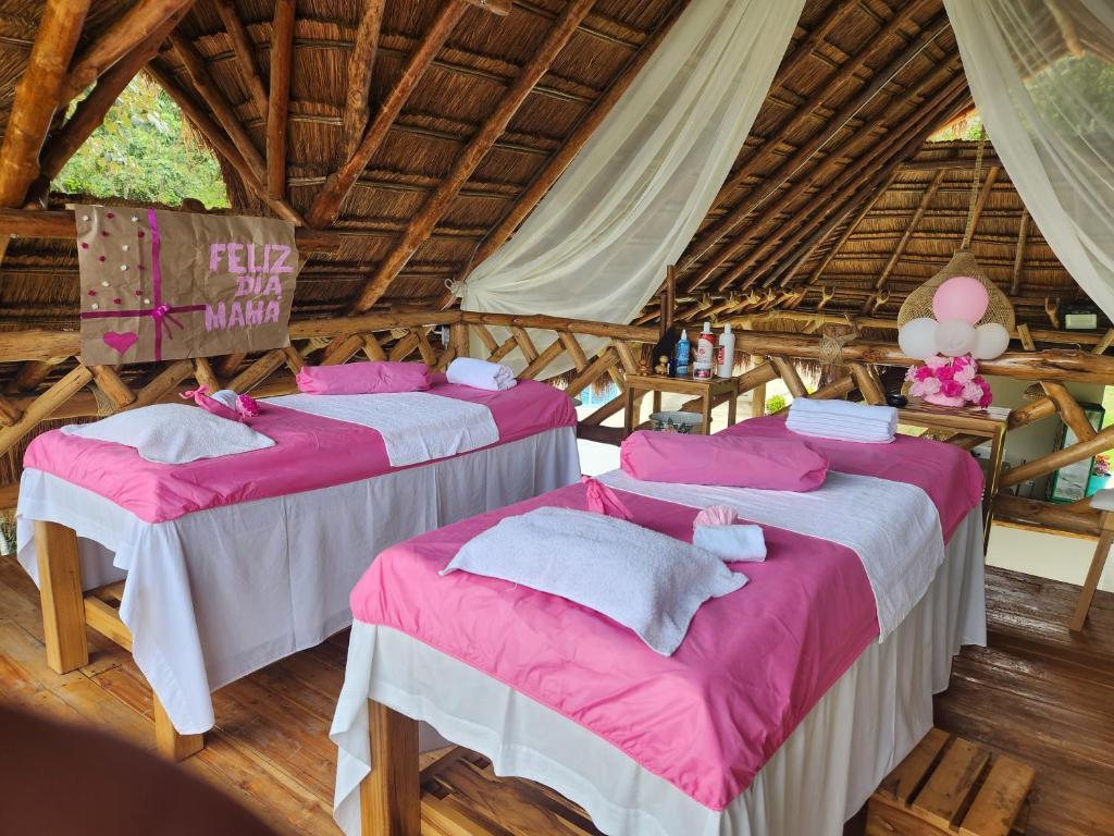 two beds in a room with pink and white sheets at Villeta Casa de Campo caracoli spa in Villeta