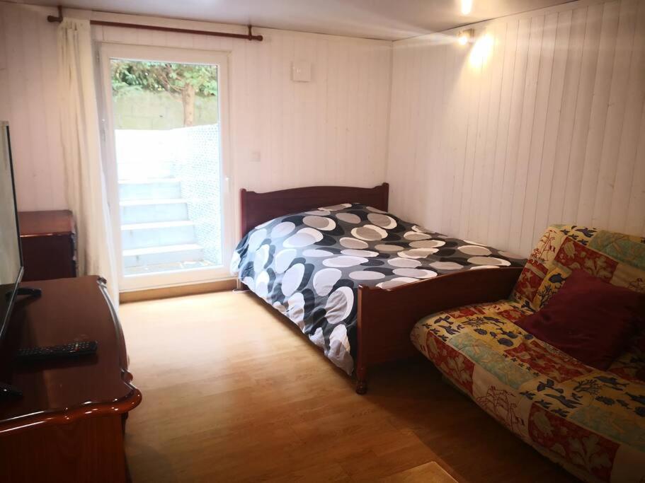 - une chambre avec un lit, un canapé et une fenêtre dans l'établissement Rooms near Paris (20mn to Paris), à La Ville-du-Bois