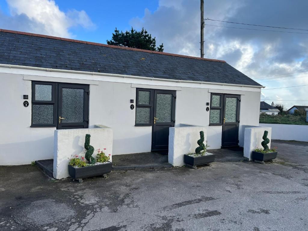 a white building with three plants in front of it at Chiverton arms in Chacewater