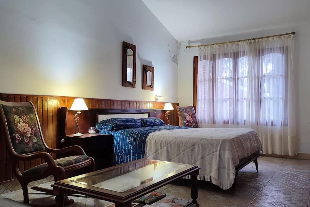 ein Schlafzimmer mit einem Bett, einem Tisch und einem Stuhl in der Unterkunft Departamento grande Tierra del sol -con pileta- A 5 minutos del estadio y del nodo tecnológico y cerca de Marcha de los bombos in La Banda