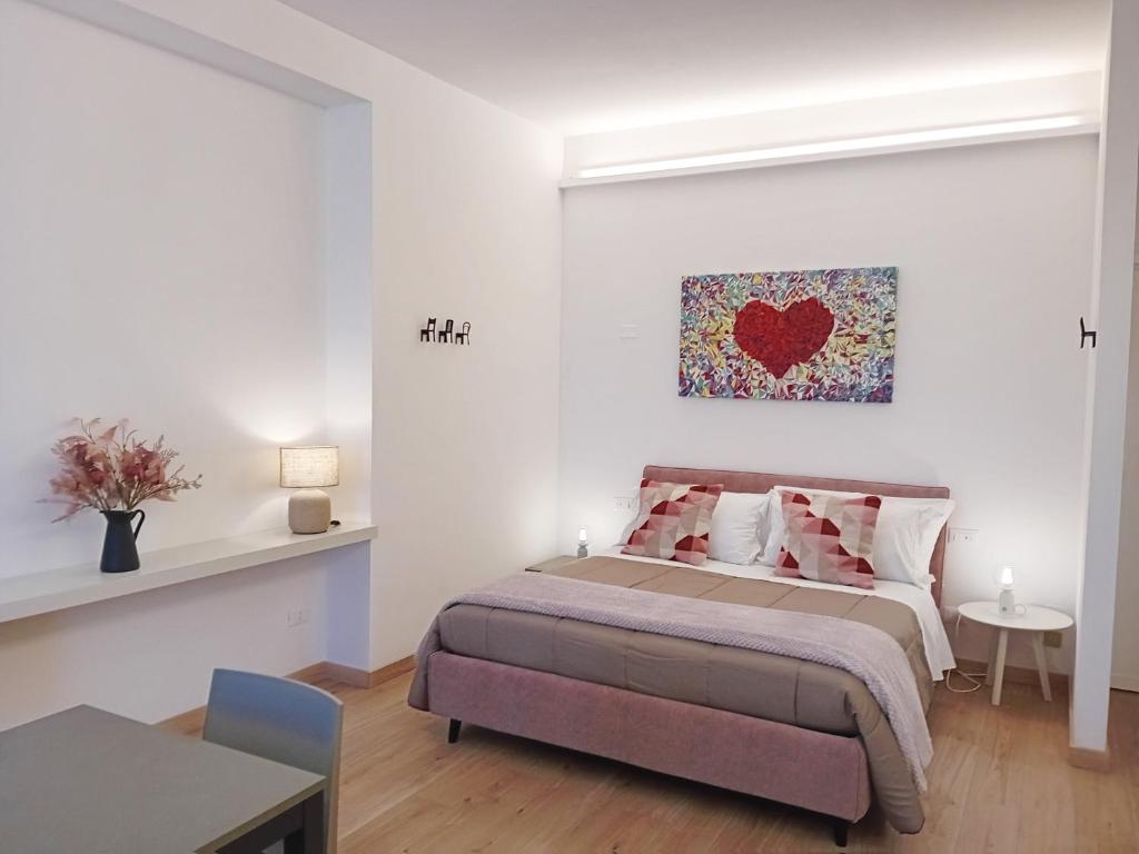 a bedroom with a bed with a heart painting on the wall at Appartamento con Terrazza Fronte Mare in Riccione