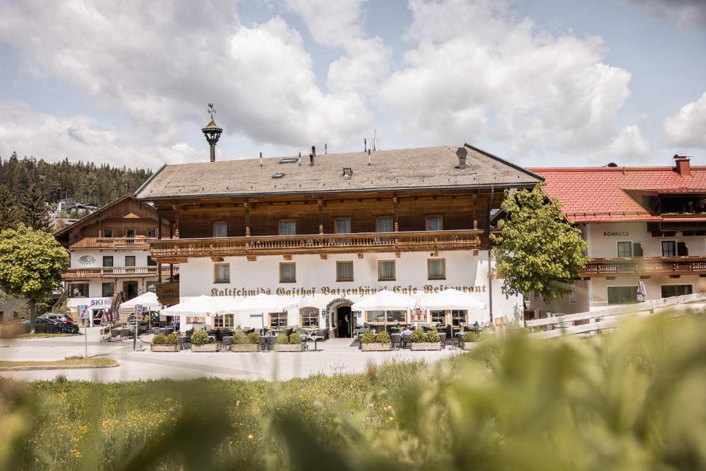 un gran edificio con mesas y sillas delante de él en Batzenhäusl, en Seefeld in Tirol