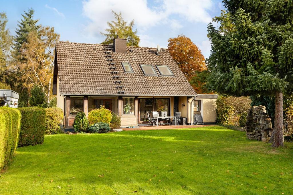 a house with a large yard with green grass at Gästehaus am Mühlenteich in Schieder-Schwalenberg