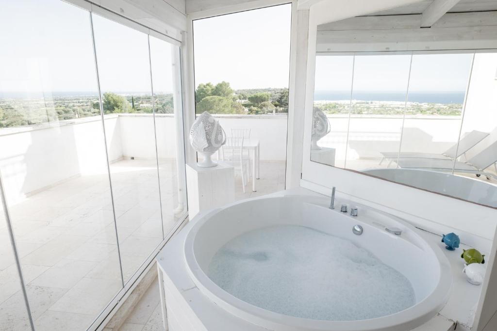 a white bathroom with a tub and a large window at San Lorenzo Boutique Hotel & SPA in Polignano a Mare