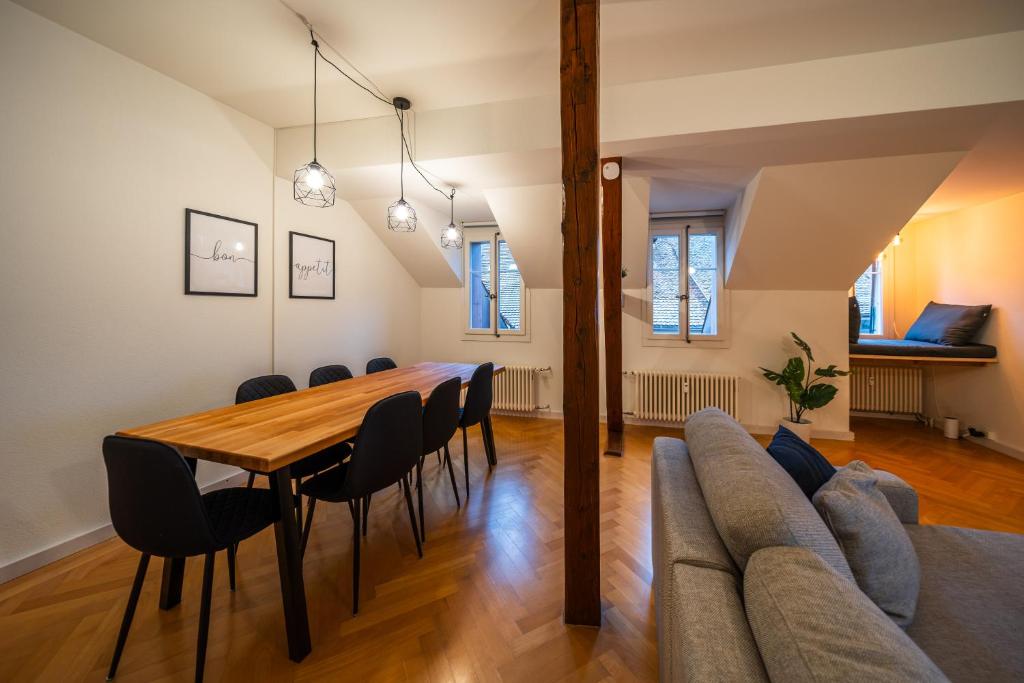 a dining room with a table and a couch at Old town apt in the heart of Thun with garden in Thun