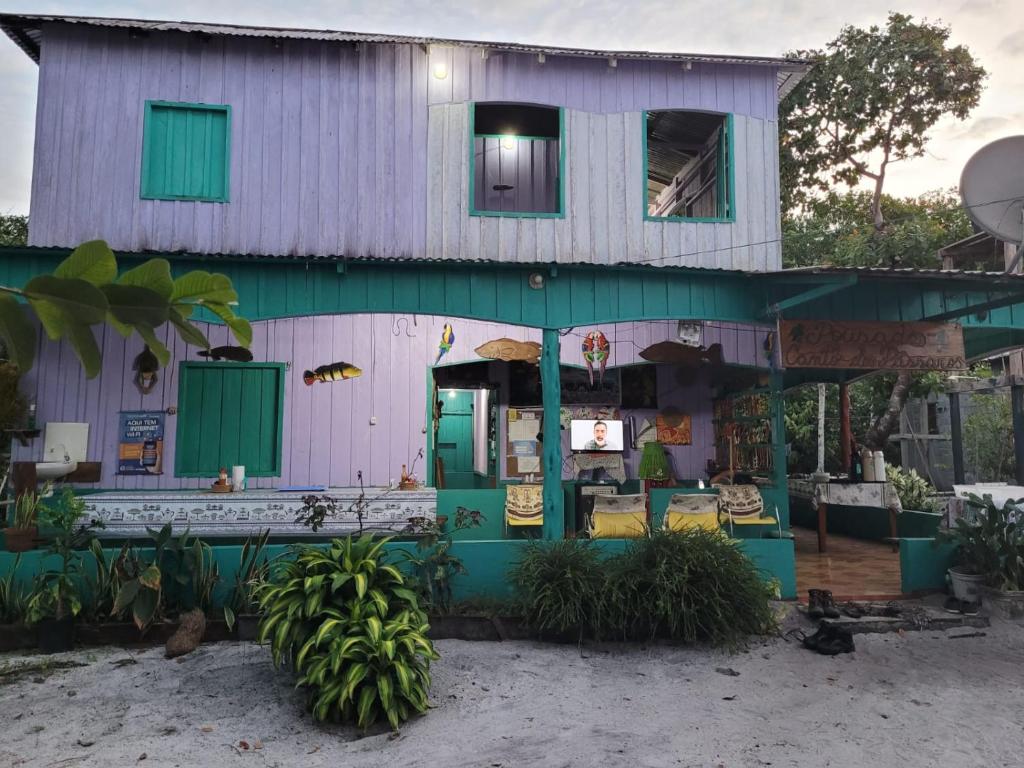 ein Haus mit lila und grüner Fassade in der Unterkunft CANTO DOS PASSAROS in Manaus