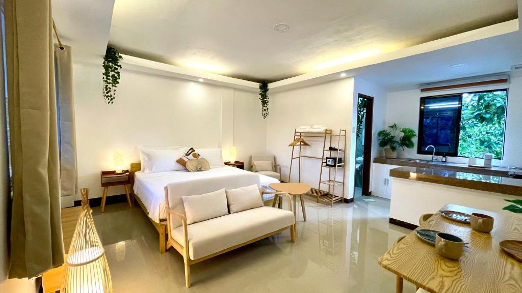 a bedroom with a bed and a chair in a room at Namal Apartelle - Free Scooter & Concierge Service in El Nido