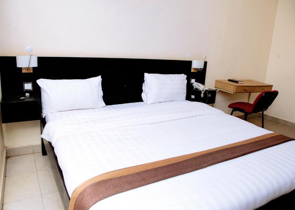 Postel nebo postele na pokoji v ubytování Ubuntu Palace Hotel Kampala