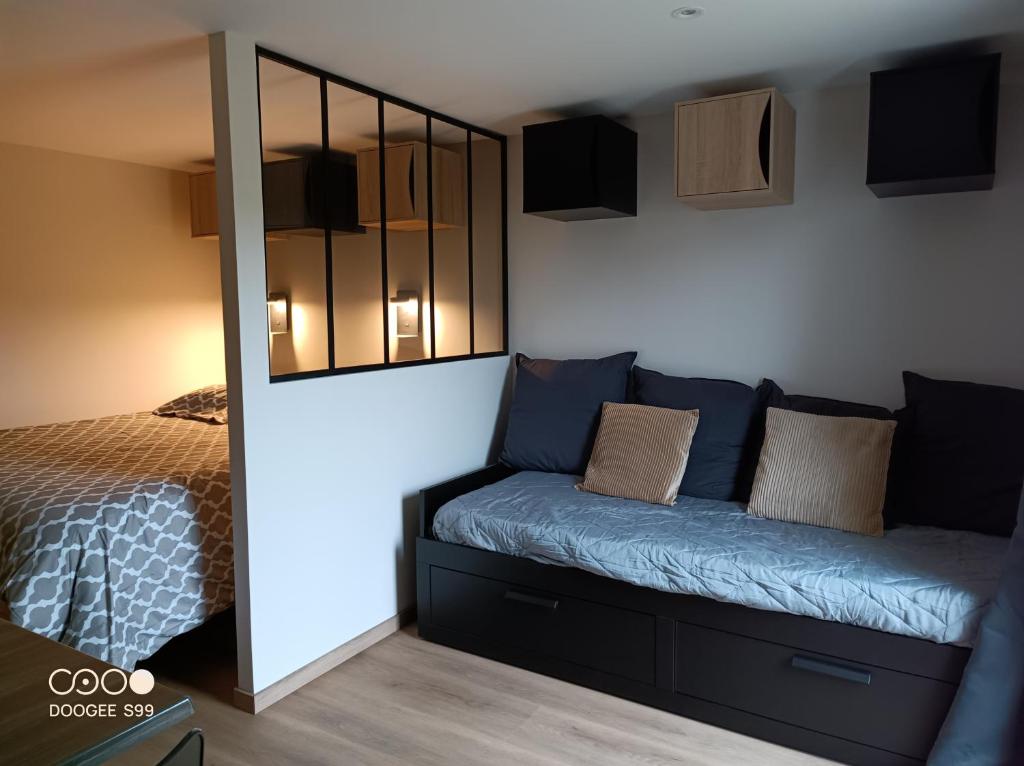 - une chambre avec un lit et un canapé bleu dans l'établissement Aux pieds de la colline de Mousson, à Pont-à-Mousson