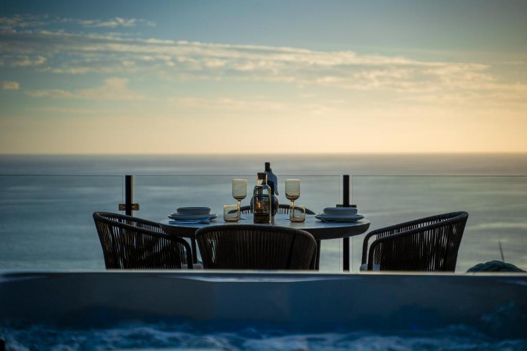uma mesa com cadeiras e copos de vinho e uma banheira em Glamping Maracujá - Oasis Paradise em Ribeira Brava