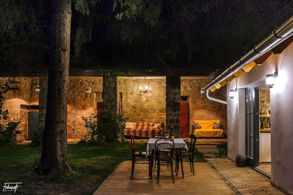 a table and chairs on a patio at night at ZebRegény Vendégház in Zebegény