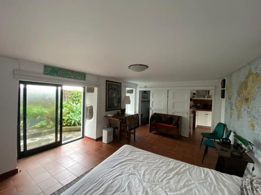 a bedroom with a bed and a living room at Caboz Inn in Horta