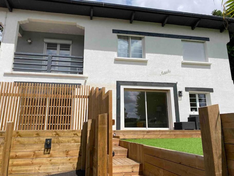 une maison avec une clôture en bois devant elle dans l'établissement Jolie Maison à 5mins des plages et du lac, à Soorts-Hossegor