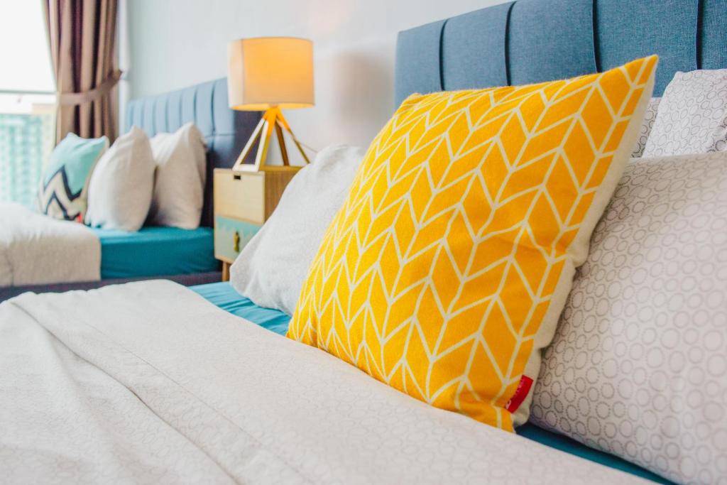 Una cama con una almohada amarilla y blanca. en -Lake View- Mount Austin IKEA Toppen 10 mins - B113, en Johor Bahru