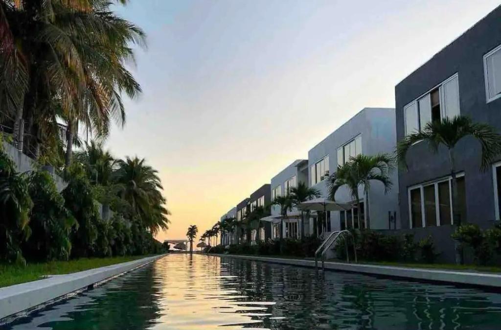 a canal with buildings and palm trees next to a building at Another Day In Paradise in San Luis La Herradura