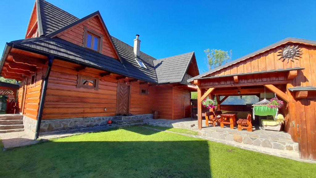 Cette grande maison en bois dispose d'une terrasse dans la cour. dans l'établissement Drevenica Deni, à Osturňa