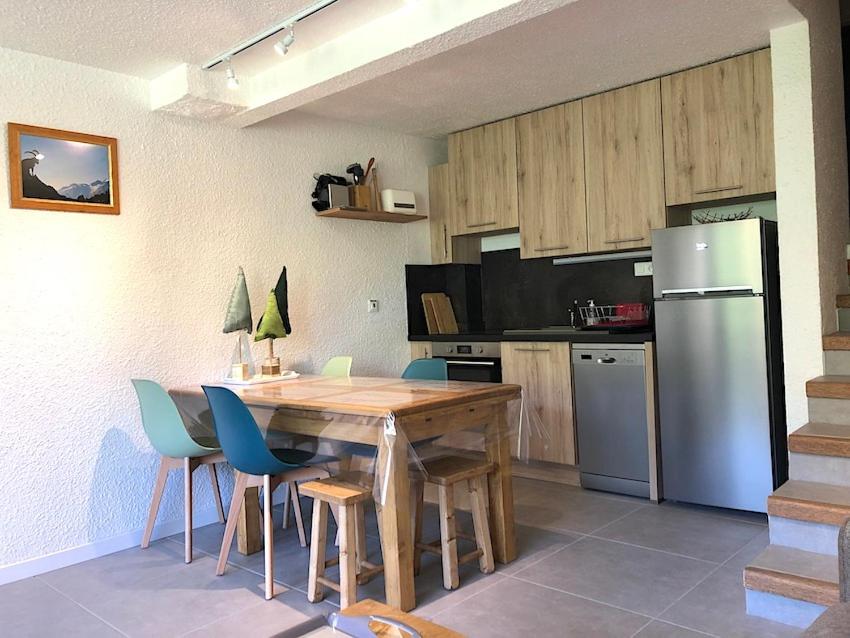 une cuisine avec une table en bois et un réfrigérateur dans l'établissement LES SAPINS Joséphine Immobilier, à Saint-Chaffrey