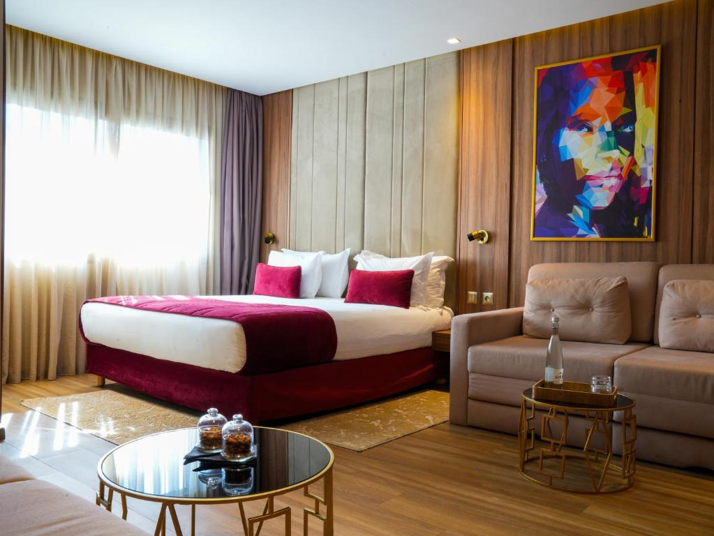 Postel nebo postele na pokoji v ubytování First Suites Hôtel