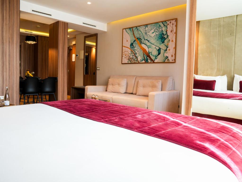 Postel nebo postele na pokoji v ubytování First Suites Hôtel