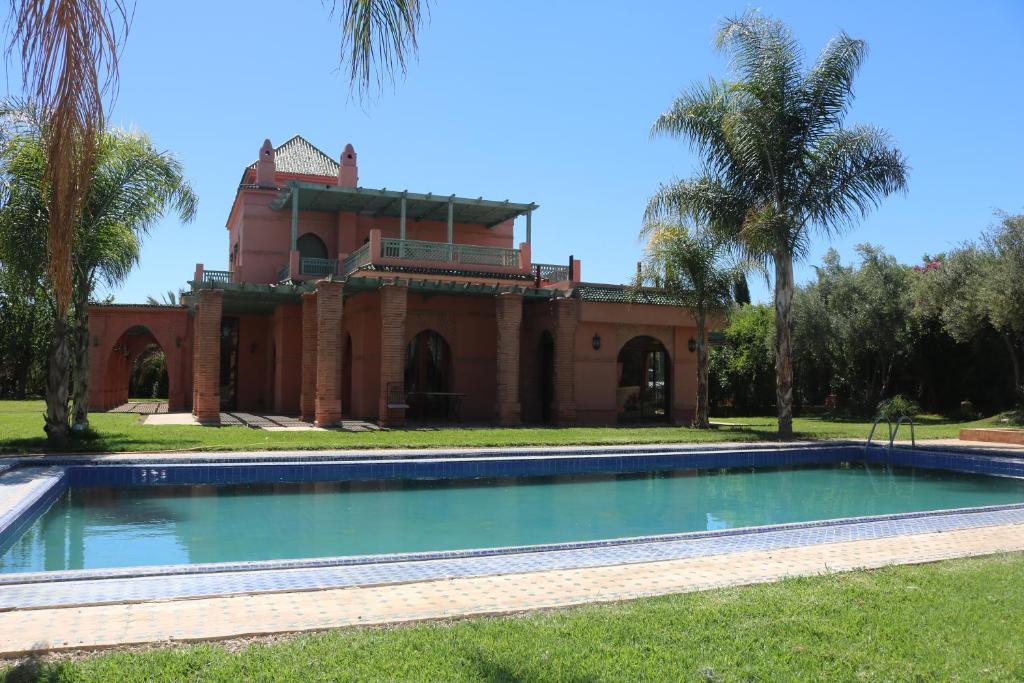 une piscine vide en face d'une maison dans l'établissement nakhil villa palm, à Marrakech