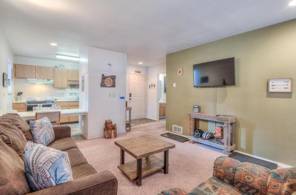 a living room with a couch and a tv and a table at Powder Village Unit D8 in Sunriver