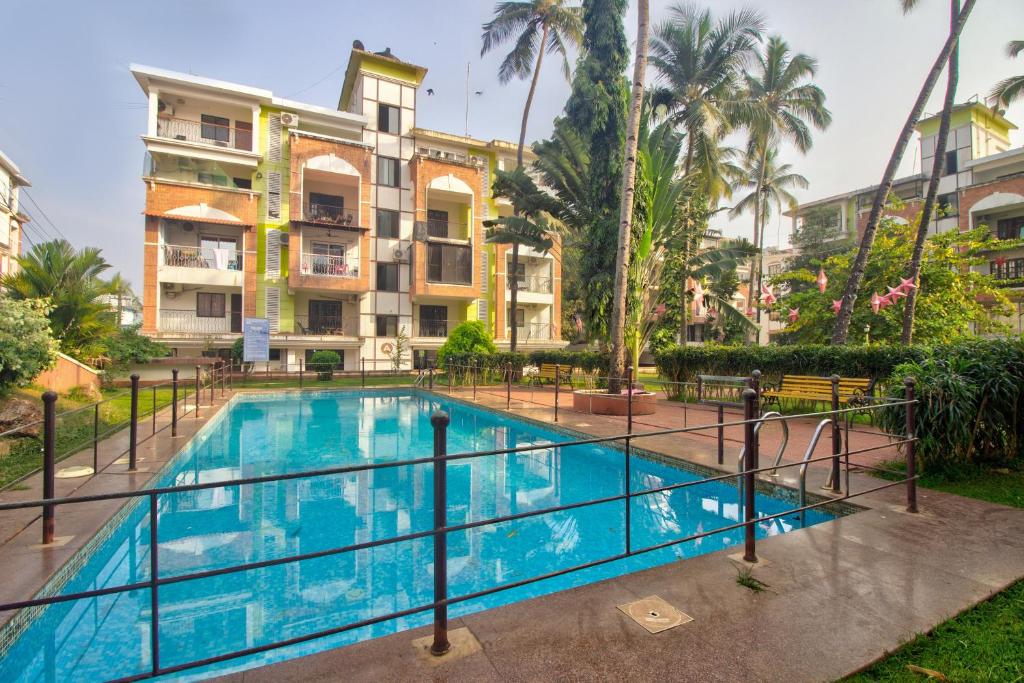 a swimming pool in front of a building at Amazing Pool View Candolim Goa 1BHK Apartment in Candolim