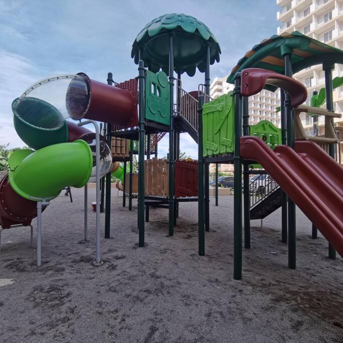 un gruppo di attrezzature per il parco giochi di Affordable Condo w/ Wi-Fi, Pool & Shower Heater a Lapu Lapu City