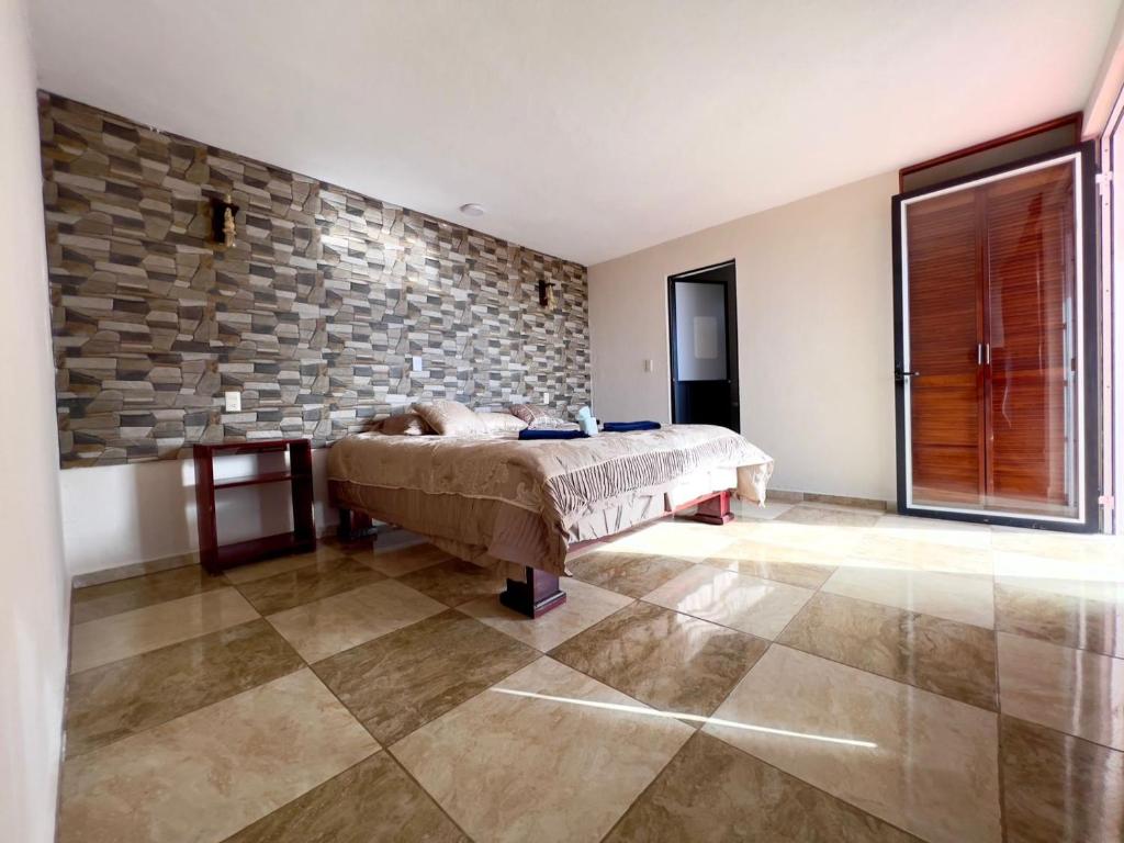 a bedroom with a bed and a stone wall at Cabañas el gigante in San Jose del Pacifico