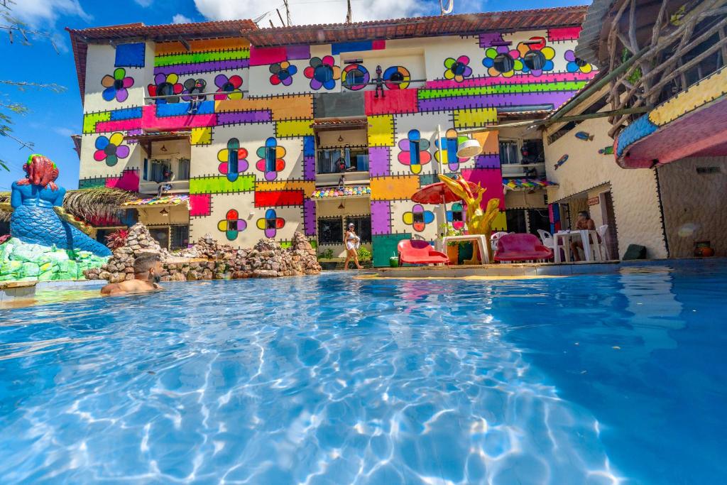 a swimming pool in front of a building at Pousada das Galinhas in Porto De Galinhas