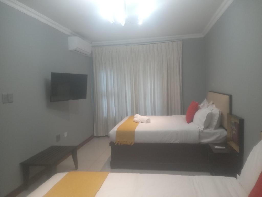 a hotel room with a bed and a window at Villa54 in Gaborone