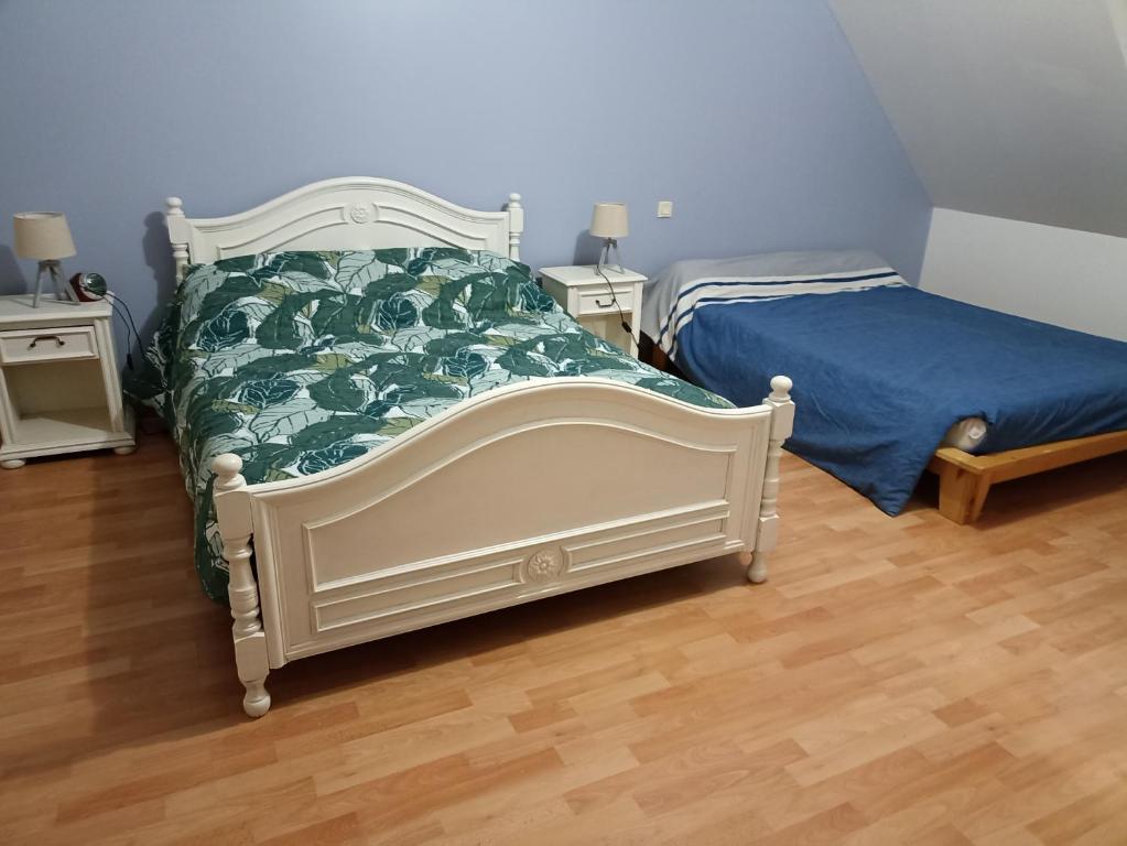 Een bed of bedden in een kamer bij chambre chez l&#39;habitant proche circuit 24 h